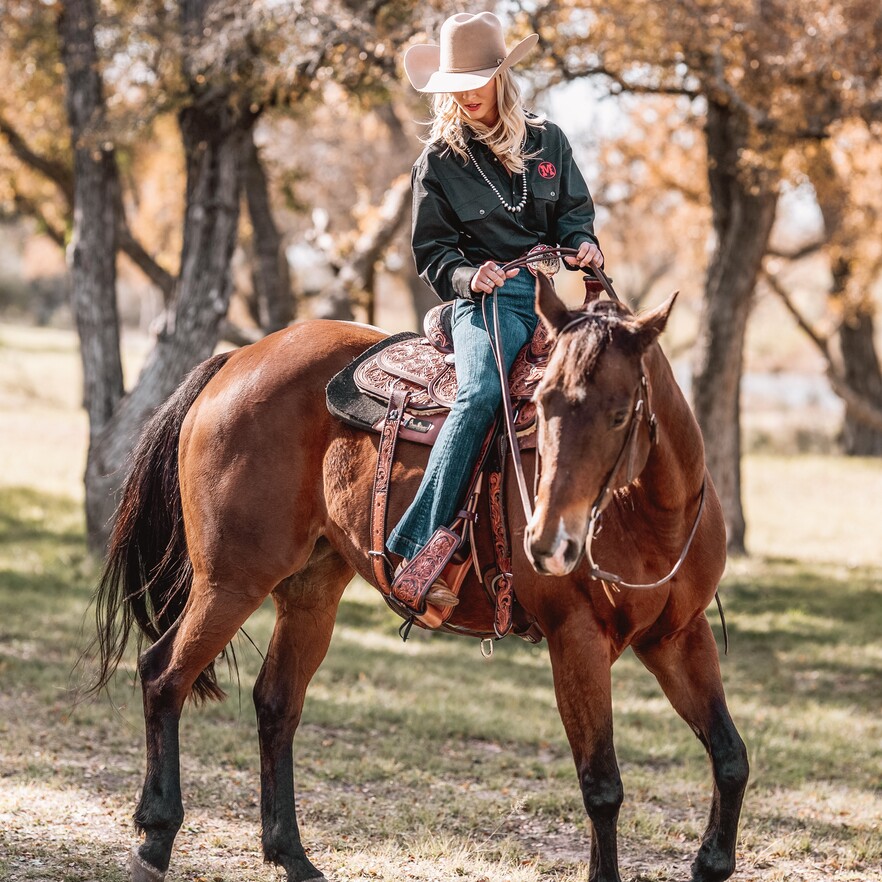 Cowgirl riding a horse on a roping saddle